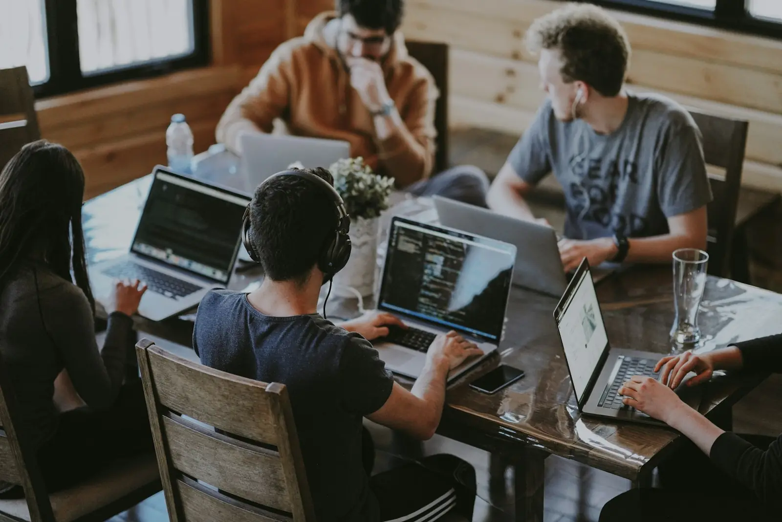 Product team working on laptops around a shared table